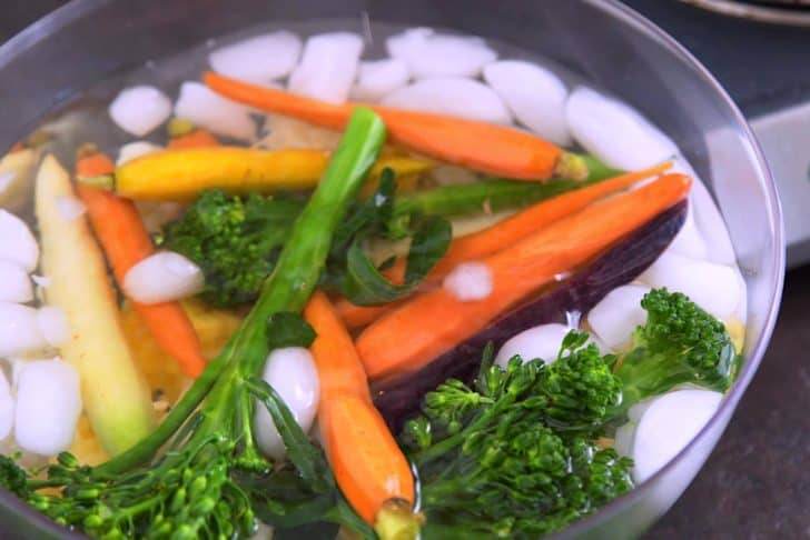 Transfer blanched vegetables to an ice bath immediately to cool.
